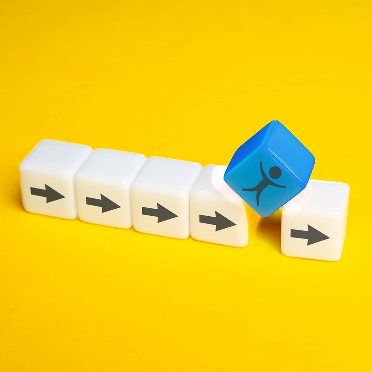 Six cubes in a row on yellow background: five cubes are white, each with a gray arrow pointing right on its face. However, there is a small gap between the fourth and fifth white cubes: a blue cube with a sketched figure in gray on its face closes this gap with its bottom edge. The blue cube has a emojis on it.